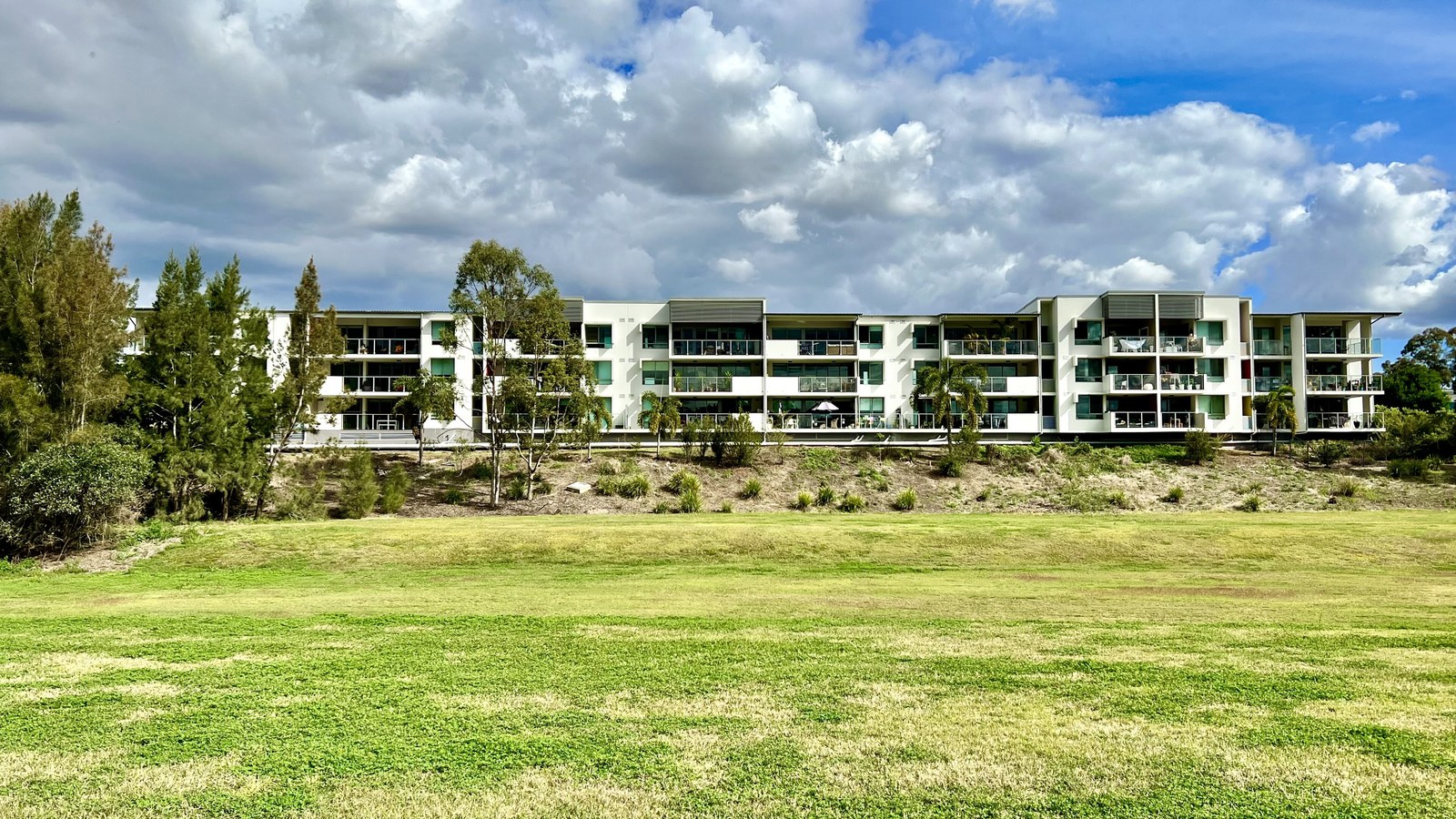 Four-storey apartment building above green parkland