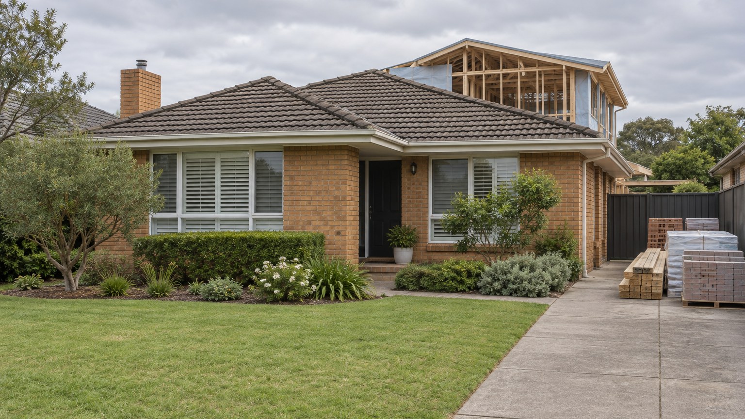 Brick suburban house with a partly built rear addition behind the original roof