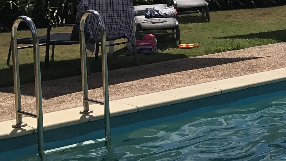 Residential swimming pool with entry ladder and lawn