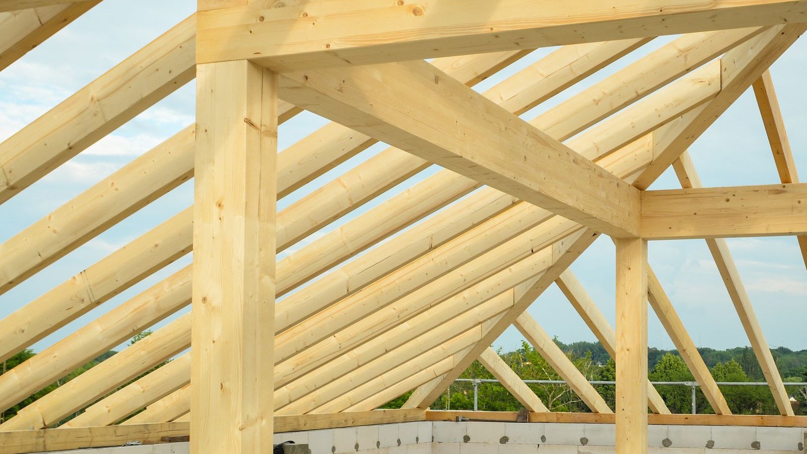 Timber roof frame under construction above a slab