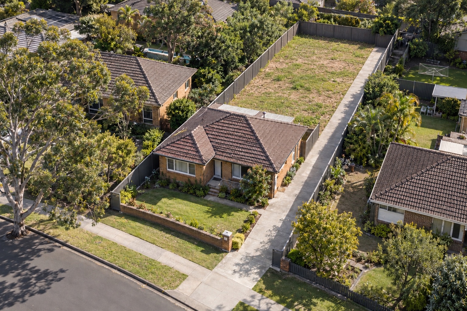 Front house with a side driveway leading to a vacant rear subdivision block